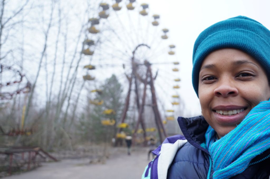 ferris wheel in the background, woman in hat in the foreground