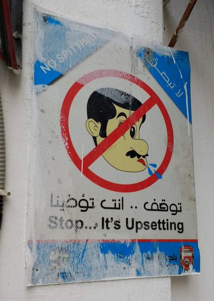 no spitting sign in English and Arabic