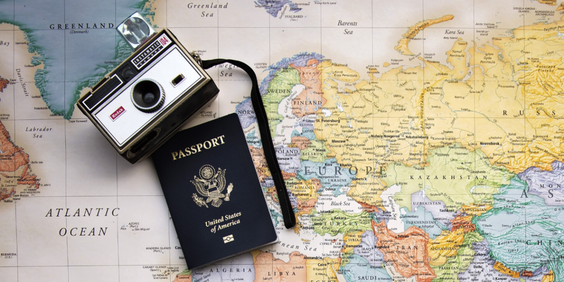 camera and passport on top of world map