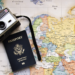 camera and passport on top of world map